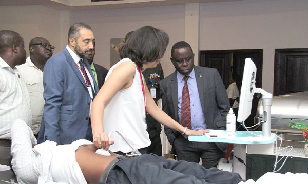 Madam Jacklin George, an Application specialist, demonstrating to Mr Mohammed Elkaliouby (behind madam Gorge), a Managing Partner, Africano Healthcare, and Dr Daniel Asare (right), CEO, Korle Bu Teaching Hospital, how the Eco Station Machine, used for measuring bone density, works. Picture: BENEDICT OBUOBI