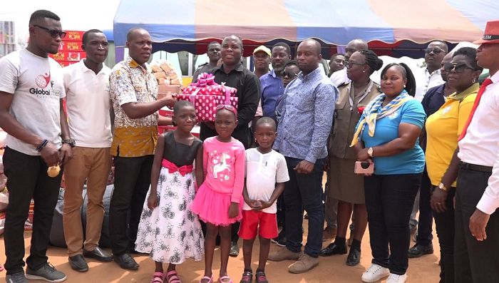 Mr Aseeph, Chairman of the GPHA Senior Staff Union (in black) presenting the items to Mr Asiedu. With them members of the union and children at the orphanage.