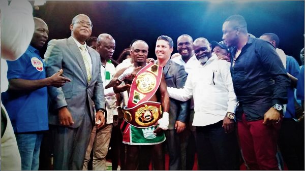 Emmanuel Tagoe is assisted by boxing legend Azumah Nelson (second right) to wear the tittle belts. Picture: PRINCE DORNU-LEIKU