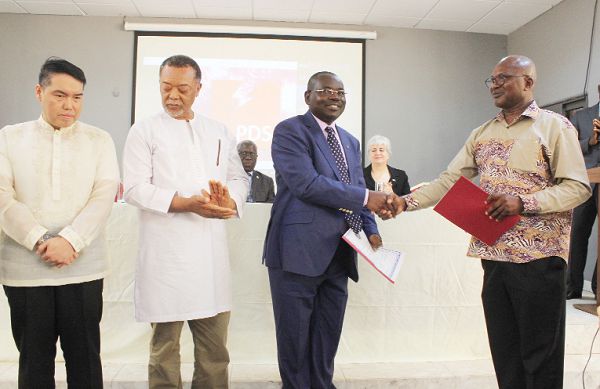 Mr Alfred Ofosu Ahenkorah (right), Executive Secretary of the Energy Commission, presenting a document to Mr Samuel Boakye-Appiah (3rd left), Managing Director, Electricity Company of Ghana. Looking on is Mr Ireneo B. Acuna (left), Vice President and Head, Electric Distribution Development Group.  Picture: INNOCENT K. OWUSU