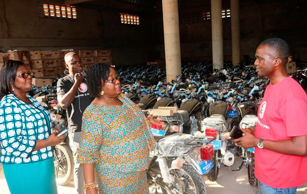 Mrs Elizaberth Agyemang (middle), makes a point to Mr Micheal Yeboah (right), during an inspection of the motor bikes at the warehouse of JSA Logistics Ghana Limited in Kumasi. Looking on is Mrs Emelia Botwey (left)