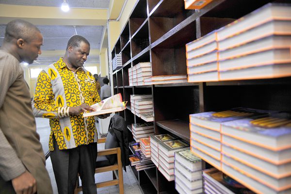 Dr Yaw Osei Adutwum, Deputy Minister in Charge of General Education glancing through a book at the Central Library in Accra .With him is  Mr Hayford Siaw,the Ag Chief Executive Officer of the GLA. Picture: Emmanuel Quaye 