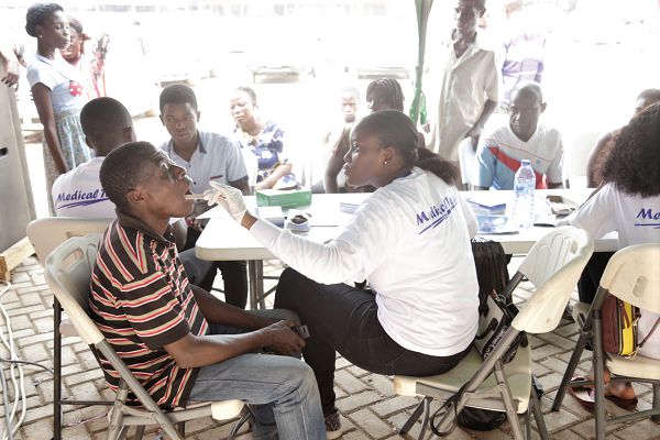The OKS medical team attending to patients at the health screening exercise at Awoshie in Accra. INSET: Dr Ohene Kwabena Safo, CEO, OKS Medical Consult, making a statement at the event