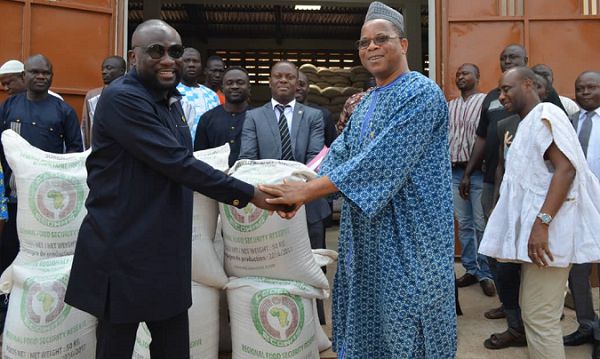 Alhaji Abdul-Wahab (left) and Mr Sangare (2nd right) in a handshake after the handover of the grains, while Dr Sagre Bambangi (right) and other staff from ECOWAS and NAFCO look on
