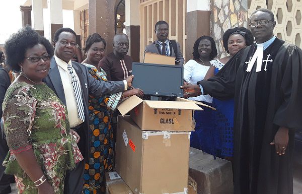 Mr Hanson Obeng Asamoah (2nd left), presenting the items to Rev. Christian Amankwa Kwafo (1st right). With them are some members of the association and the church.