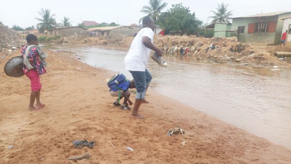  At Ayigbe Town, this young man together with the school boy were spotted removing their shoes to cross the stream