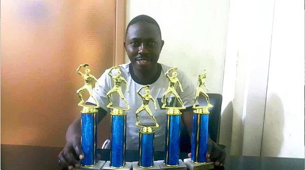  Courage Nanevie —Displaying the trophies he won during the competitions  in USA