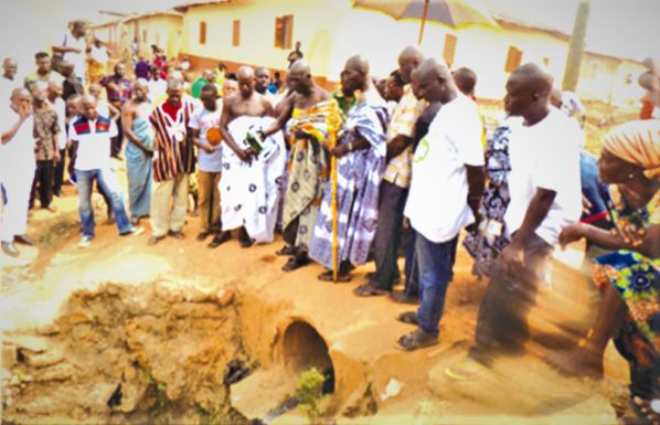 A linguist pouring libation for the commencement of the project