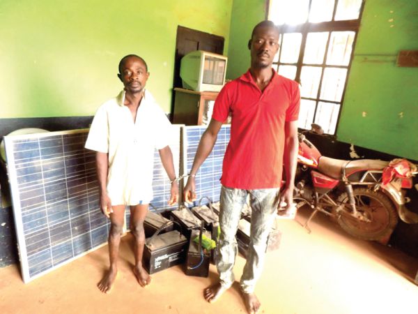 Sampson Amponsah (left) and Matthew Bayor (right) standing near the solar panels and batteries retrieved from them.
