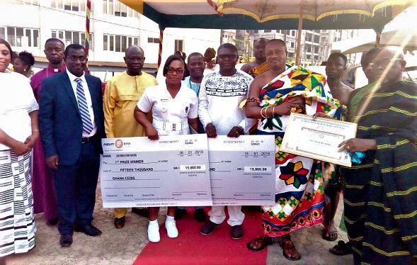 Overall best workers, Dr Adabie Appiah and Jemima, a nurse, displaying their dummy cheques. With them are the Bantamahene (right)