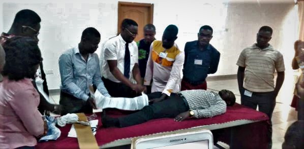 Dr Konadu-Yehoah (in tie) demonstrating how accident victims with fractured leg should be handled before being sent to the hospital