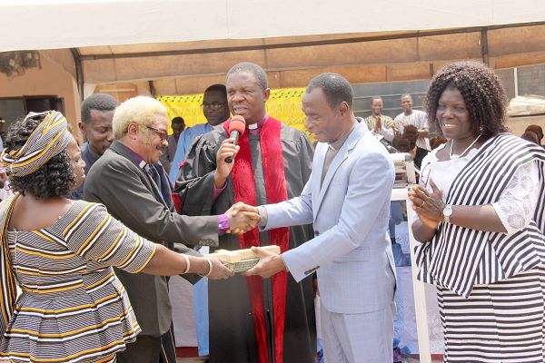Rev. Daniel Yaw Gbande (2nd right), the out-going General Overseer of the Evangelical Church of Ghana handing over a Bible and a cross to Rev. Maxwell K.K. Liwangul (2nd left), the in-coming General Overseer of the church. Picture: EDNA ADU-SERWAA
