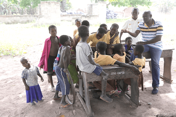 Mr Severious Kale-Dery (right) interacting with some of the pupils, while Mr Fodjour looks on
