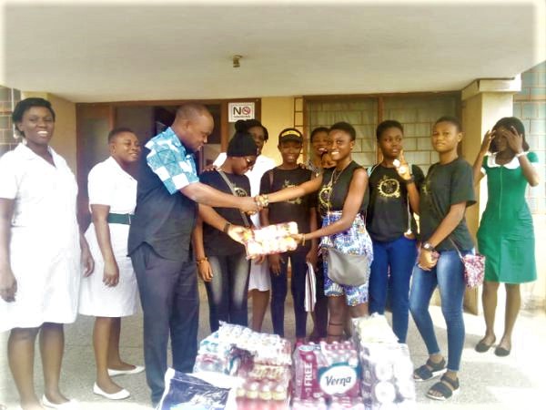 Ms Iena-Joan Nana Kwartemaa Freeman, Founder of the foundation, presenting part of the items to Dr Kingsley Addo, while members of the group look on