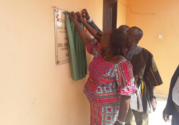 Mrs. Christie Esi Bobobee  being assisted by Mr. Braimah, the Savannah Regional Minister to unveil a plaque to Inaugurate the conference hall for the Central Gonja Assembly