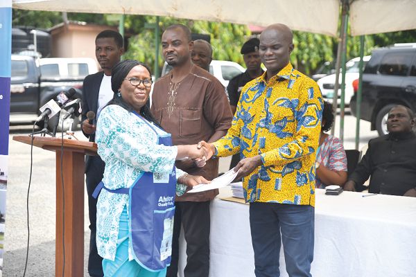 Mr Francis Kingsley Ato Codjoe presenting a certificate to Madam Emelia Nortey, a beneficiary, in Accra yesterday. Picture: EMMANUEL QUAYE 