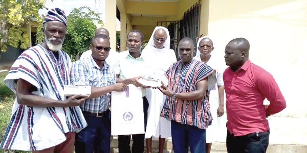 Mr Kusubari (2nd right) handing over the anti-snake venom to Dr Anlaagmen (3rd left) at the West Gonja Hospital as some staff members of the hospital look on