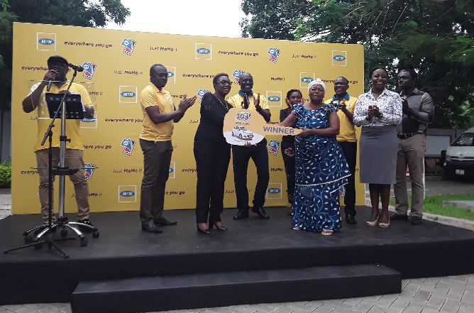  Mrs Georgina Asare Fiagbenu (left), Senior Corporate Communications Manager, MTN Ghana, presenting a symbolic key to Mrs Rebecca Quaye. With them are executives of MTN.