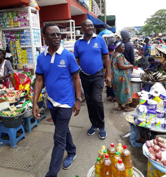Mr Samuel Sarpong (in front), MD of NIB and a member of staff of NIB in the market