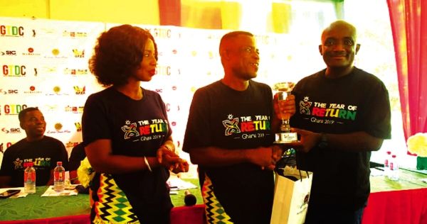 Teye Lartey recieving his prize from the CEO of GTDC, Kwadwo Odame Antwi (right) with his deputy, Akofa Dokosi, looking on