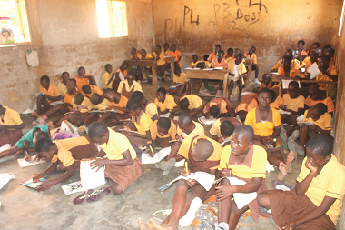 A combined class with most of the pupils sitting on the bare floor