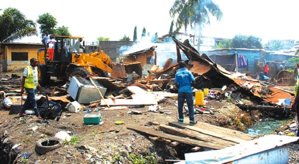 An bulldozer pulling down some of the illegal structures at Abofu, Achimota