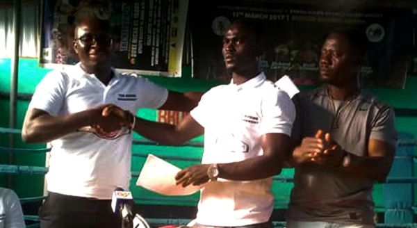 Richman Ashiley (middle) receiving the contract from James Okwam