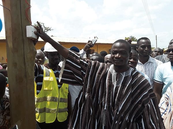 Mr Abdul Salam Hamza Fataw switching on one of the lights on an electricity pole at Kumbong-Yipelinaayili to inaugurate the electrification project