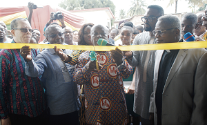 Mr Kwaku Agyeman-Manu (3rd right) being assisted by Dr Anthony Nsiah Asare (2nd left)  to cut the tape to inaugurate the Oduman Polyclinic