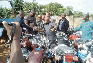  Dr Archibald Yao Letsa (middle), the Volta Regional Minister, receiving keys to the motorbikes from Mr Felix Mensah Nii Anag-La (left)