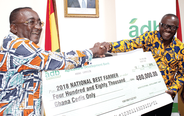 Mr Afriyie Owusu Akoto (left), Minister of Food and Agriculture presenting a dummy cheque to Mr James Obeng Boateng (right), the national best farmer for 2018 in Accra today