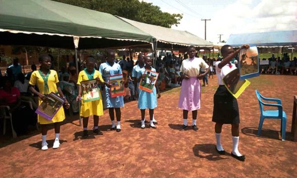 Ms Sarafina Akisicchab (right) leading a group of students to demostrate the effect of child labour, with the display of pictures.