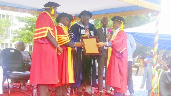 Chancellor of RMU, Dr James Kollie (right), presenting the citation to former President Kufuor