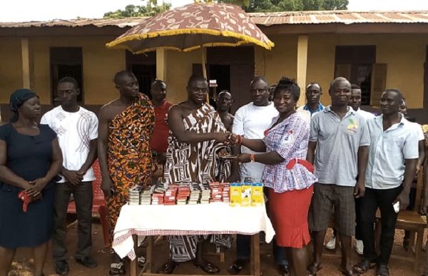 Baffour Amoateng (4th left) presenting a set of mathematical sets and pens to the headmistress of Jachie Anglican JHS at Jachie, Ms Cecilia Adu towards the just ended BECE.