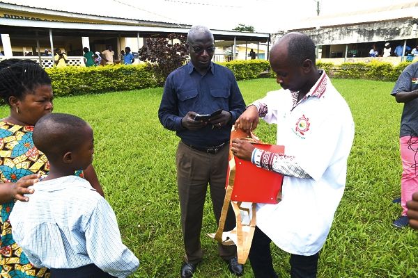 Nii Obodai Mensah (right), Head of Pharmacy, Asamankese Government Hospital, unpacking the drugs delivered by the Zipline Medical drone for Master Ohene Kwaku (left). With them are Kwaku’s mother, Ms Ellen Ofori, and Mr Edward Attuah, a pharmacist at the Asamankese Government Hospital. Inset: The drone dropping the drug
