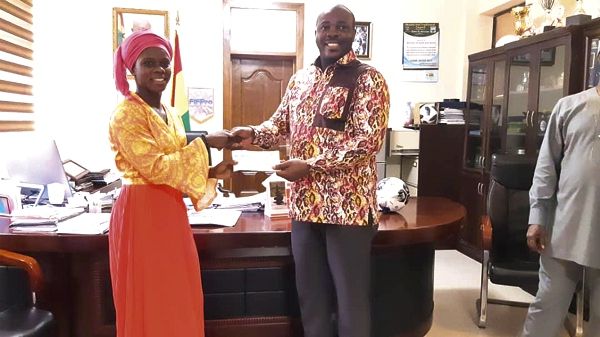  Isaac Asiamah presenting the cheque to Mukarama Abdulai at his office yesterday