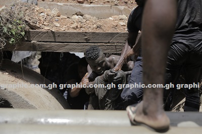 The suspected armed robber being pulled out of thetunnel in the Odaw River in Accra. PICTURES BY EMMANUEL ASAMOAH ADDAI