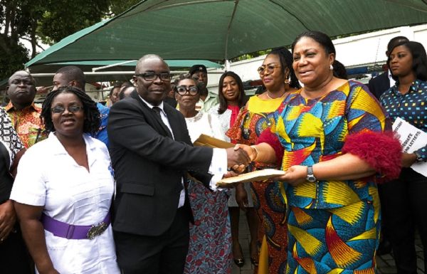 Dr Frank Owusu Sekyere, consultant paediatrician, KBTH, receiving documents on the ambulance from Mrs Akufo-Addo. On his left is Mrs Joyce Oppong Ayisi, Chief Nursing Officer, Children’s Department, KBTH.