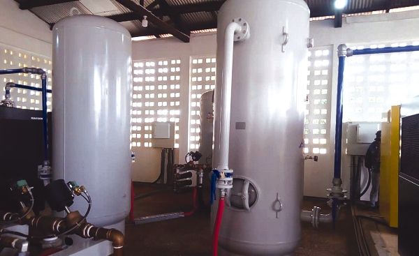 The newly commissioned oxygen plants at the Komfo Anokye Teaching Hospital in Kumasi. Below: Mrs Akosua Frema Osei-Opare (2nd-left) being assisted by Mr Simon Osei-Mensah (3rd left) to unveil the oxygen plant