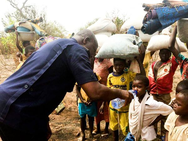Chief Supt Amankwatia, Chereponi District Police Commander, helping some internally displaced children to drink water following violence between Konkombas and Chokosis in the North East Region