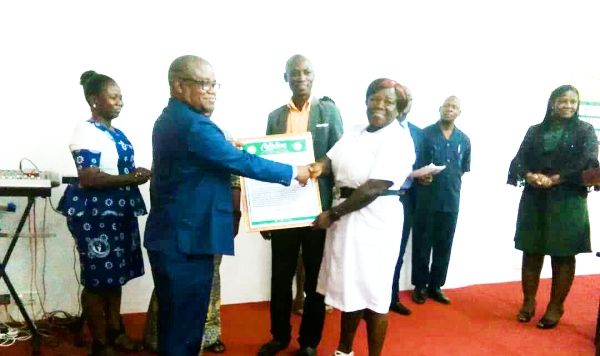 Dr Timothy Letsa (left) presenting a citation to Ms Catherine Abena Adobea for emerging the best worker for 2018