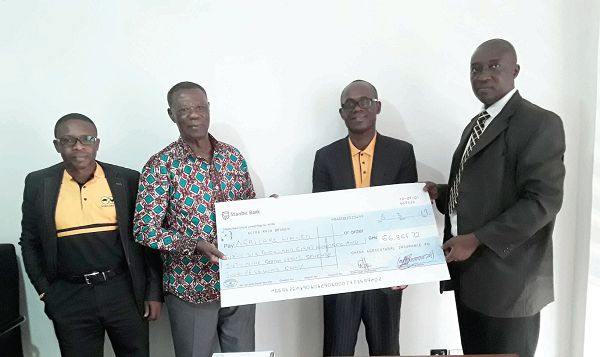 Mr Jerry Quantson (right) presenting a dummy cheque to Dr Kofi Agyekumhene (2nd left) with Mr Isaac Ferkah (2nd right) and Mr Noah Bioh, the Human Resource Manager of Agricare, looking on.