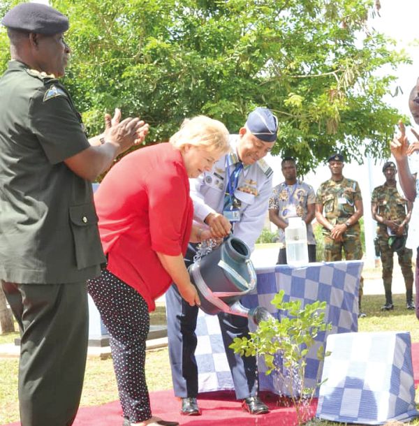 Ms Erna Solberg (2nd left) being assisted by Air Vice-Marshall Griffiths Evans (right), Commandant, Kofi Annan International Peacekeeping Training  Centre, to water a tree she planted, as Lt Gen Obed Akwa (left), the Chief of the Defence Staff, looks on. Picture: NII MARTEY M. BOTCHWAY