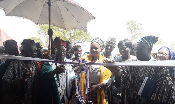 The Kusul-Lana, Yakubu Alhassan (with scissors), being assisted by Hajia Balchisu and the Country Director of CCFC, Mr Baiden, to cut the tape to inaugurate the health facility 