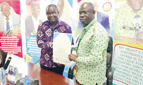 Mr Krufi (right) and Mr Amarquaye exhibiting the punctuality pledge after they had both signed