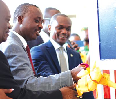 Mr Yaw Adom Boateng (in blue suit), MD of NSIA Insurance being supported by Mr Kofi Andoh (in grey suit), Deputy Commissioner, NIC, as well as Mr K. T. Dadzie, board member, NSIA Insurance cutting the tape to officially open the new office. 