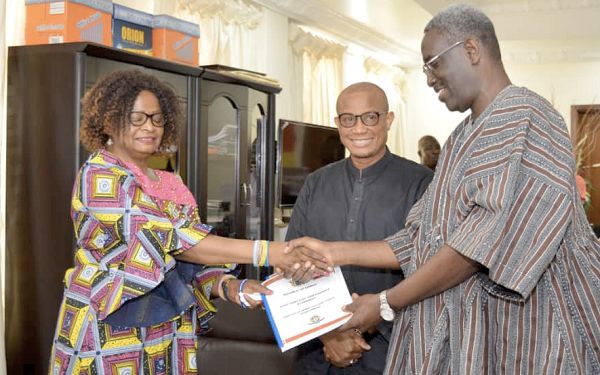Nana Agyekum Dwamena (right), Head of the Civil Service, presenting a certifcate to Mrs Gifty Mahama Biyira. With them is Dr Mustapha Abdul-Hamid