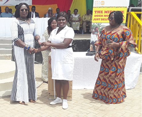 Madam Paulina Abayage (left),  presenting an award to one of the midwives who distinguished herself in her career