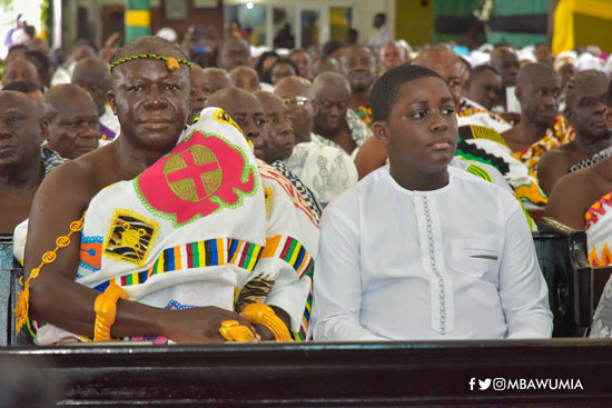 Nana Kwame Kyeretwie sits next to his father during the mass at the St Cyprian Anglican Church at Fante New Town in Kumasi.