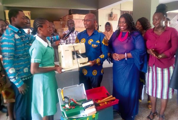 Mr Brobbey (3rd right) presenting a sewing machine to one of the beneficiaries